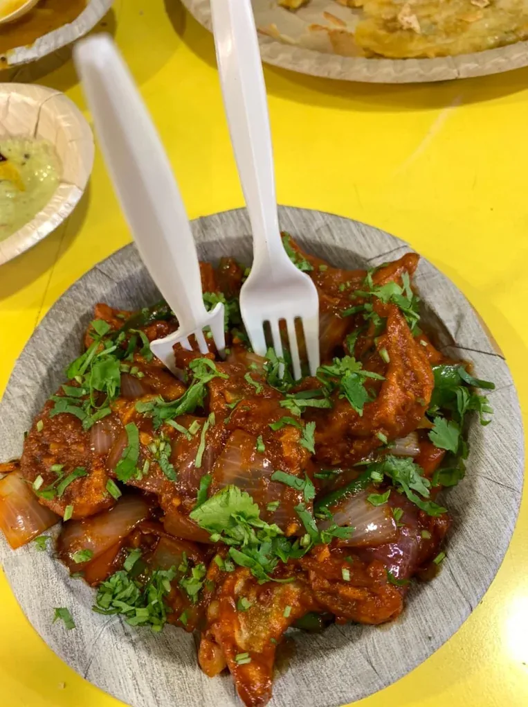 Chilli Momos tossed in red gravy with onion and coriander